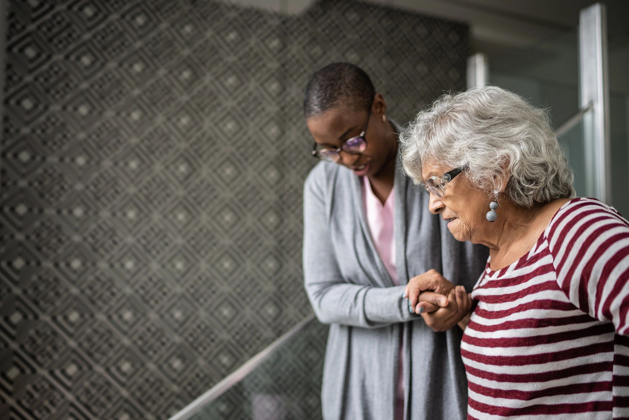 Nurse assisting a senior woman walking up stairs