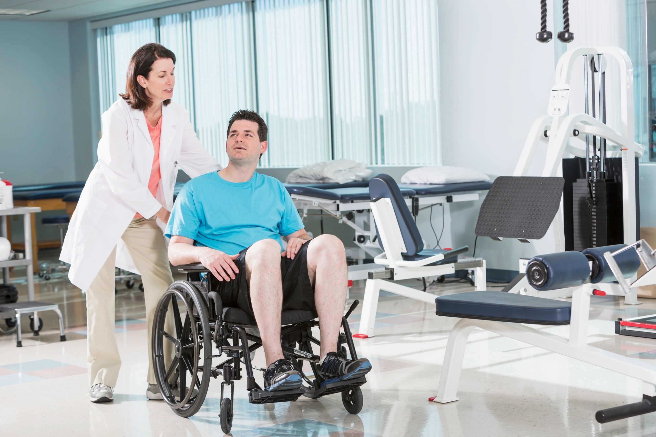 Physical therapist assisting a patient in a wheelchair