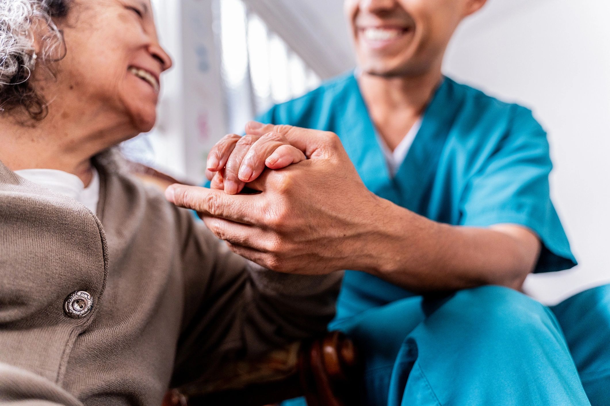 Caregiver holding a senior woman's hands
